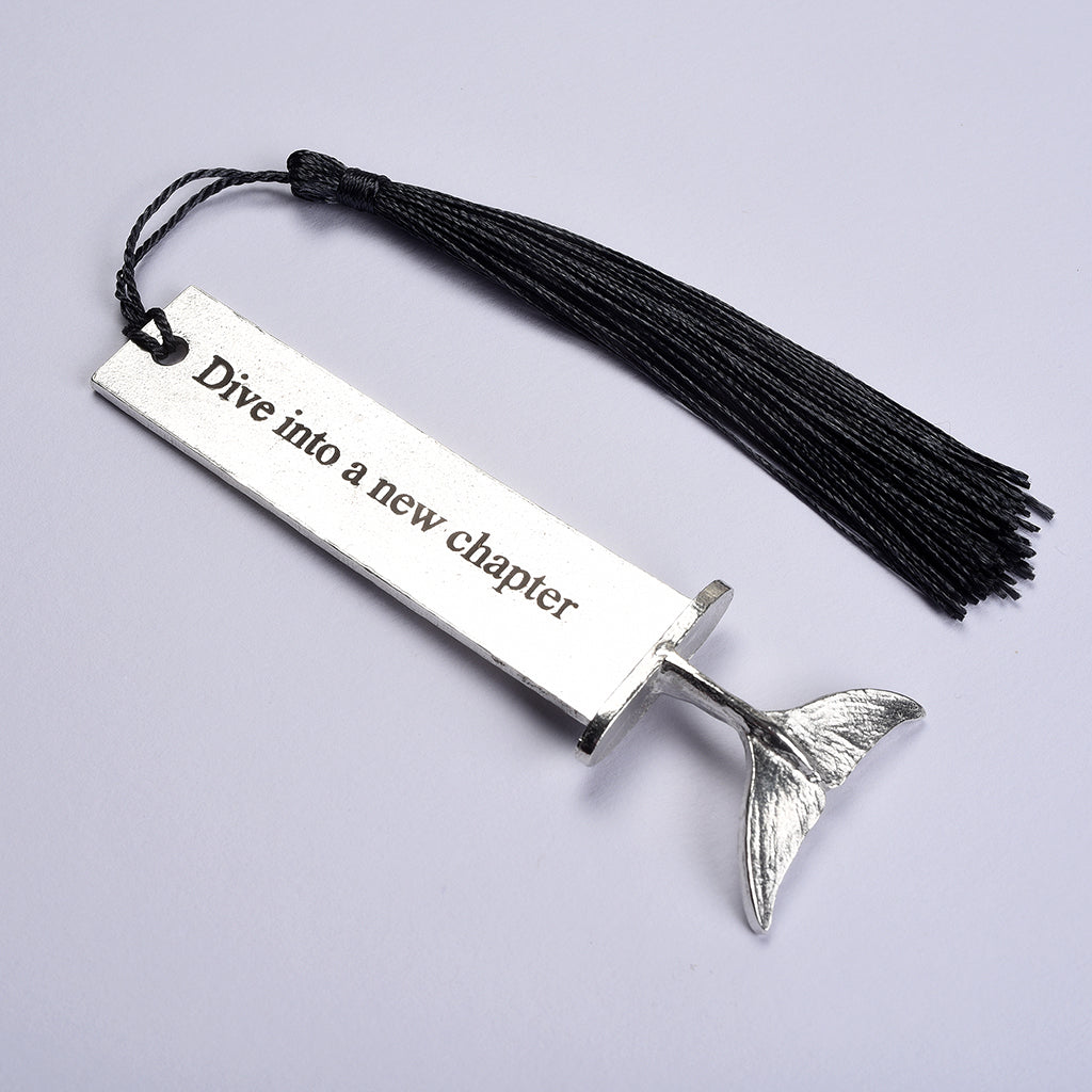 A pewter metal bookmark with a diving dolphin tail on the top. On the front the quotation 'Dive into a new chapter'. New chapter gifts, dolphin gifts,