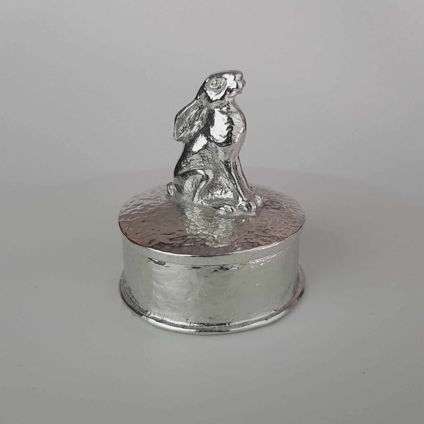 Video of a pewter trinket box with a hare sculpture on the lid. The underside of the lid can be engraved. Made by  Glover and Smith handmade pewter UK.