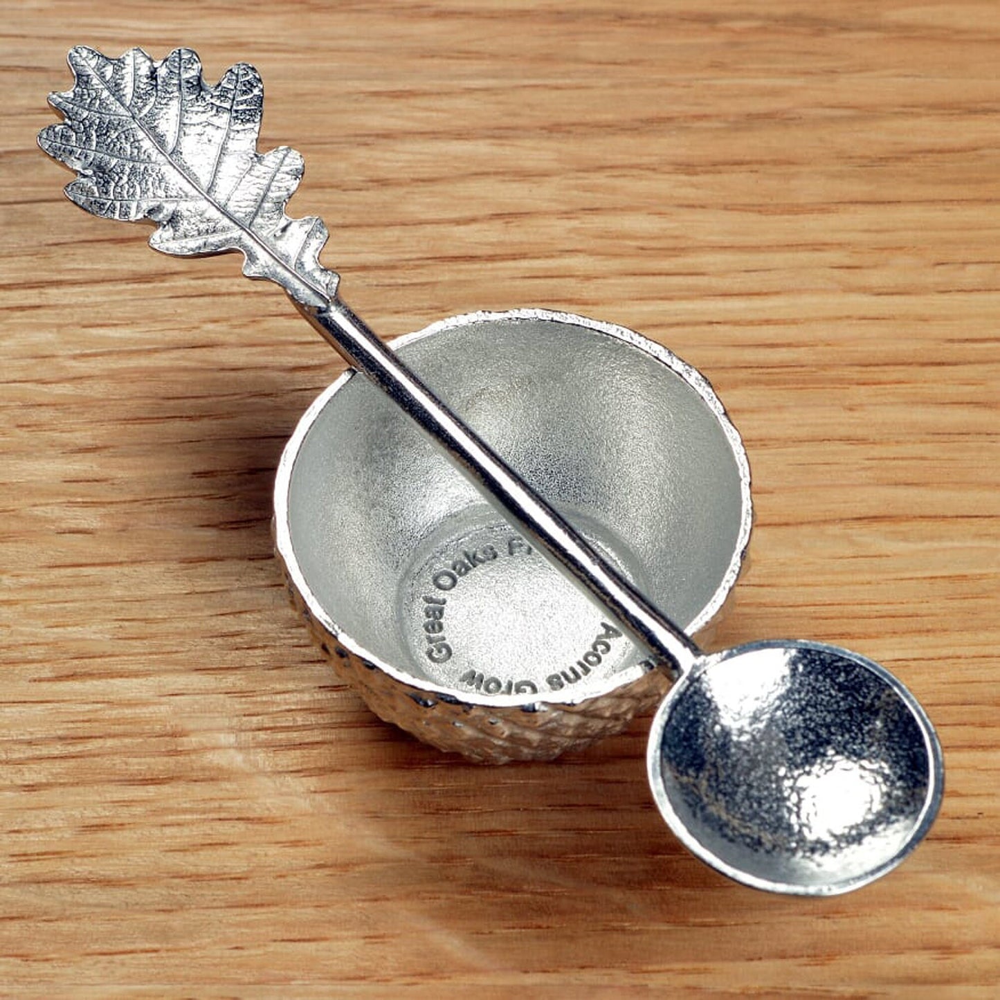 Our pewter 'Acorn Cup' egg cup features the lovely natural texture and pattern of an acorn cup and when an egg is placed in it, has the appearance of an acorn. With an oak leaf topped spoon. Christening gifts for boys and girls.