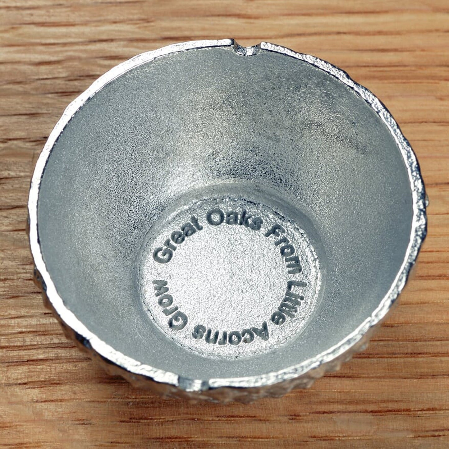 Our pewter 'Acorn Cup' egg cup features the lovely natural texture and pattern of an acorn cup and when an egg is placed in it, has the appearance of an acorn. With an oak leaf topped spoon. Christening gifts for boys and girls.