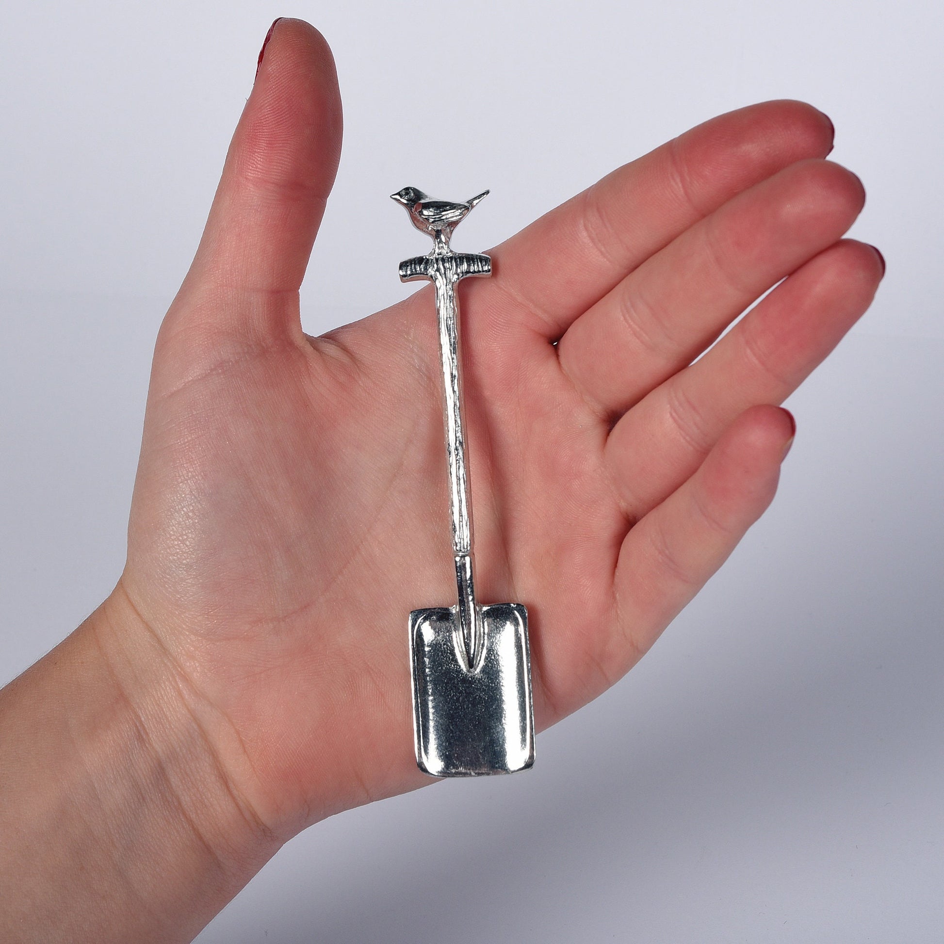 A small spoon pewter sugar spoon in the shape of a garden spade with a robin sitting on the handle . Unusual, useful and tactile gifts for gardeners gifts for bird lovers handmade in the UK