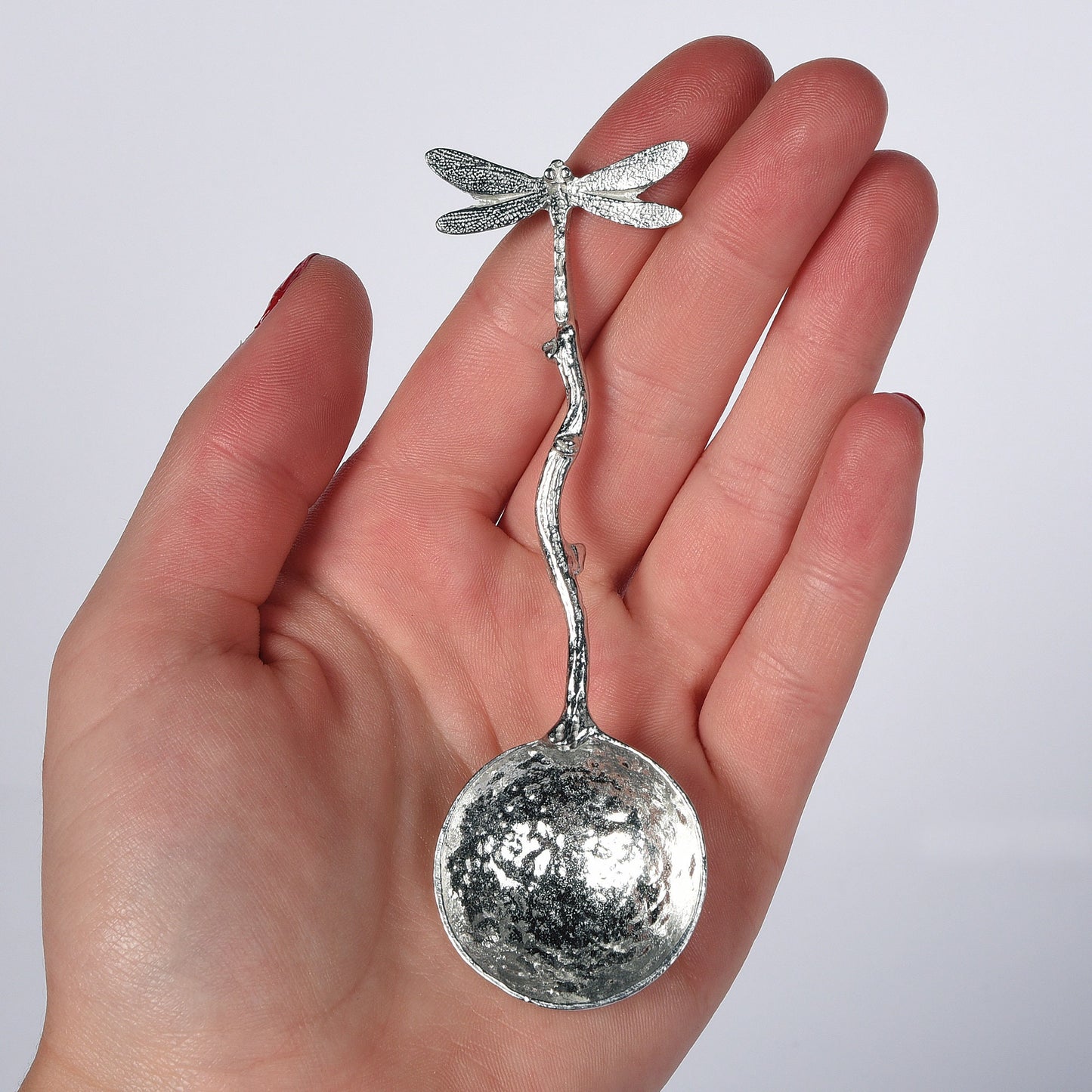 A small spoon pewter sugar spoon with a dragonfly on the end of a twig handle. Unusual, useful and tactile dragonfly gifts handmade in the UK