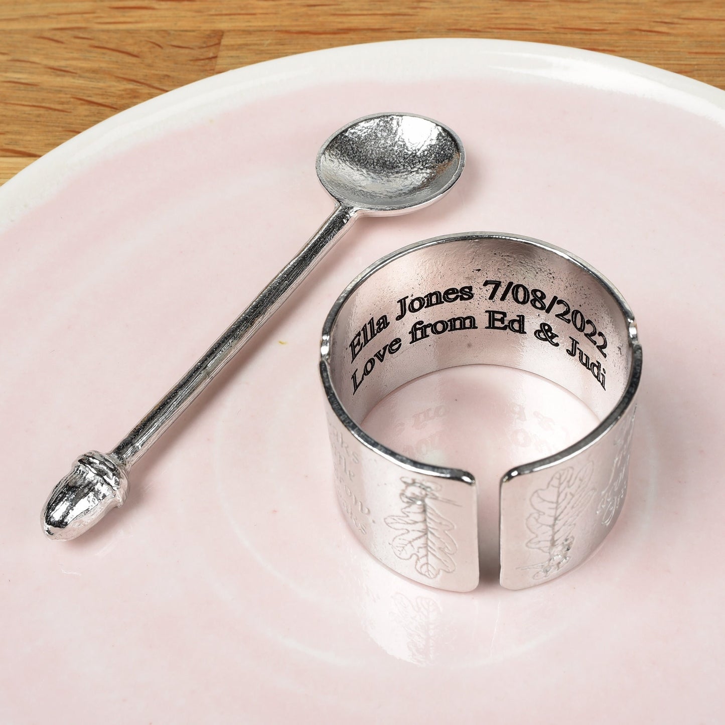 A circular egg cup with the proverb 'Great oaks from little acorns grow' written around the outside with an acorn finialled spoon. We engrave your message on the inside. Christening gifts for boys and girls.