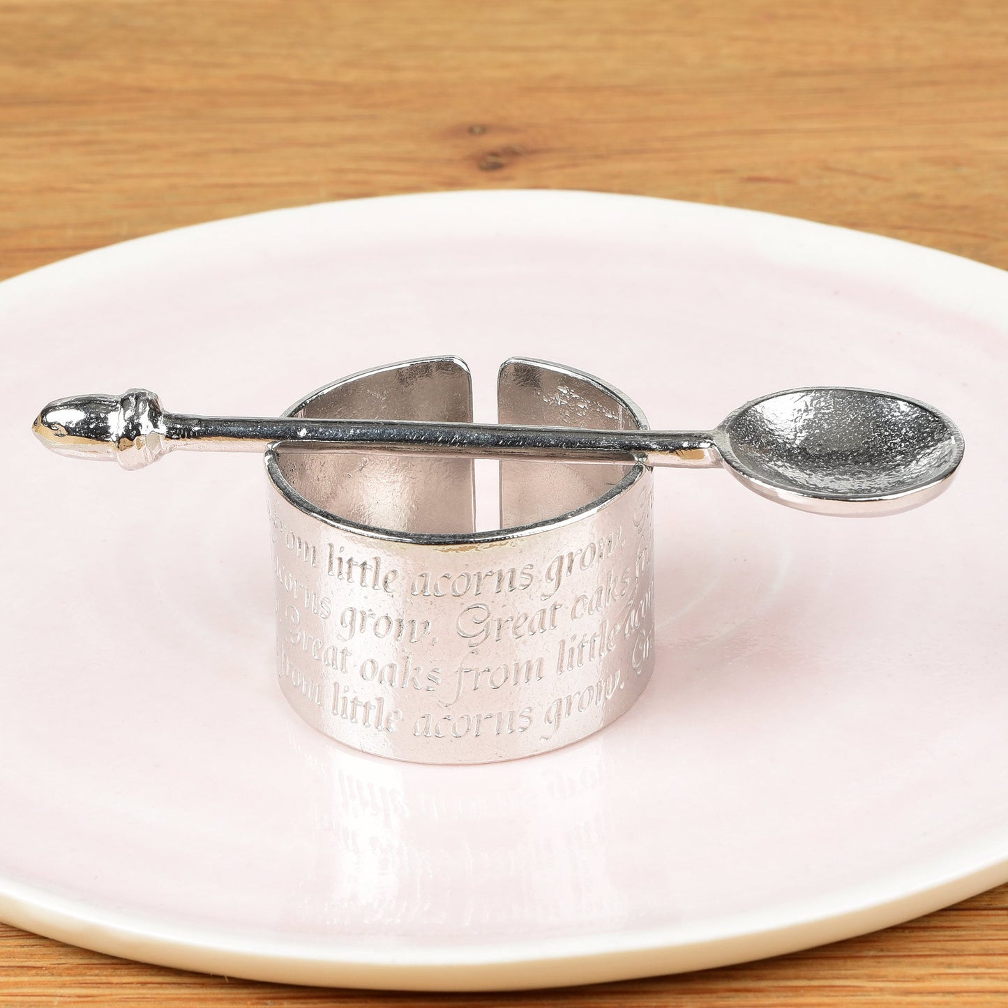 A circular egg cup with the proverb 'Great oaks from little acorns grow' written around the outside with an acorn finialled spoon. We engrave your message on the inside. Christening gifts for boys and girls.