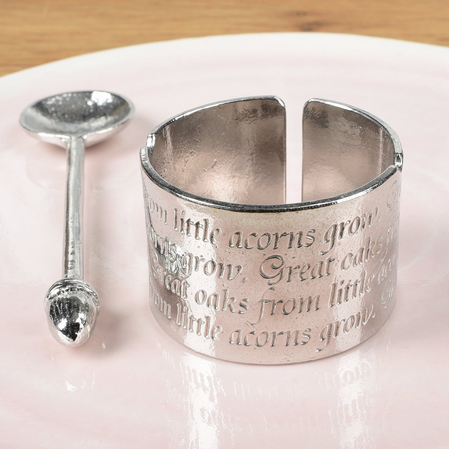A circular egg cup with the proverb 'Great oaks from little acorns grow' written around the outside with an acorn finialled spoon. We engrave your message on the inside. Christening gifts for boys and girls.