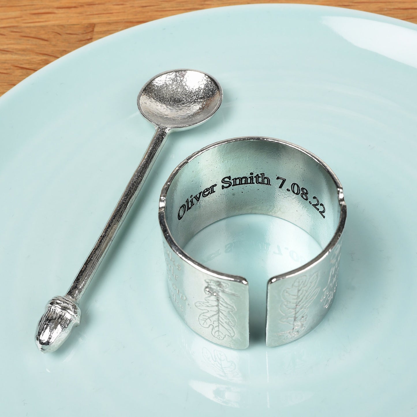 A circular egg cup with the proverb 'Great oaks from little acorns grow' written around the outside with an acorn finialled spoon. We engrave your message on the inside. Christening gifts for boys and girls.