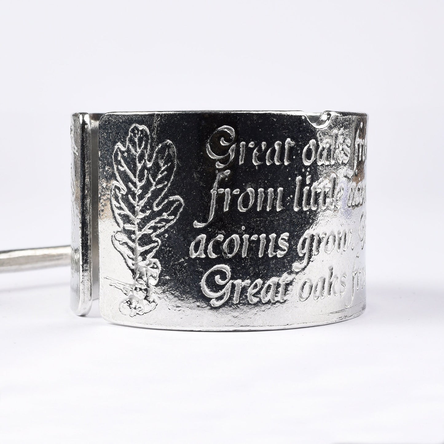 A circular egg cup with the proverb 'Great oaks from little acorns grow' written around the outside with an acorn finialled spoon. We engrave your message on the inside. Christening gifts for boys and girls.
