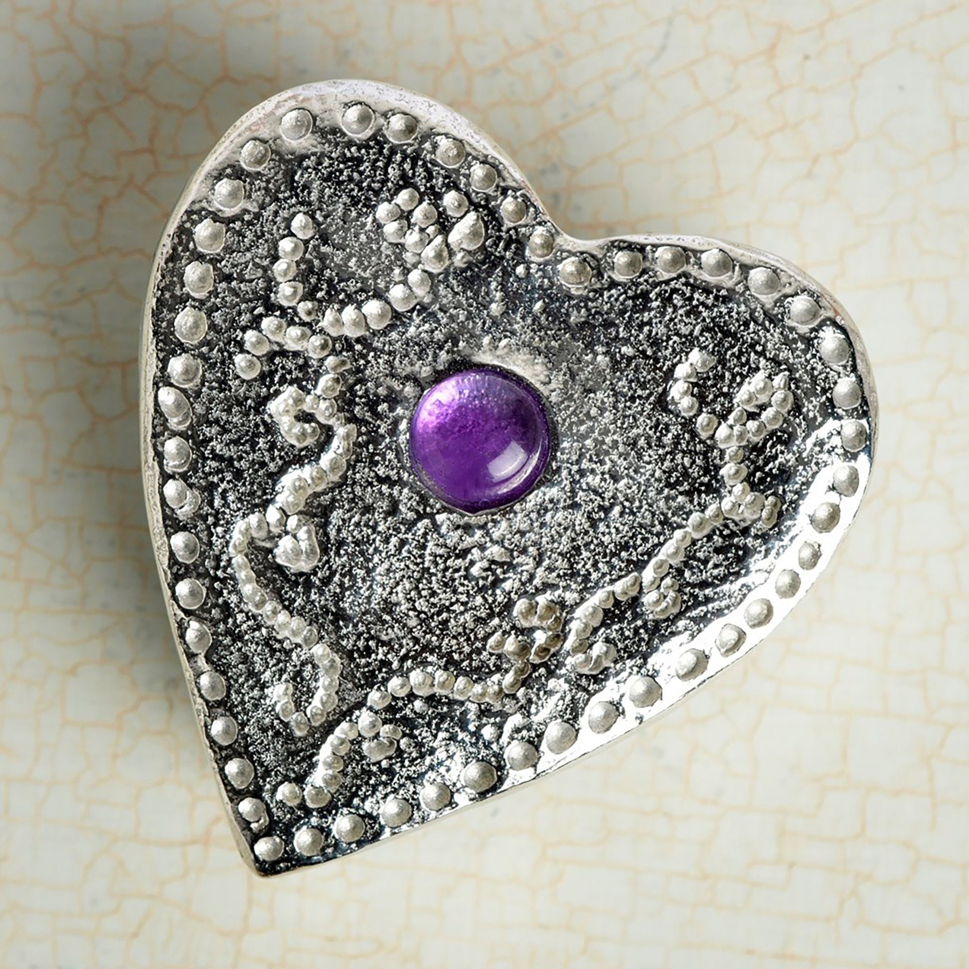 A personalised heart shaped pewter keepsake box has an amethyst stone in the middle. The underside of the lid can be engraved with your personalised message. A perfect 10th (Tin) ten year wedding anniversary gift (Our pewter is 95% tin).