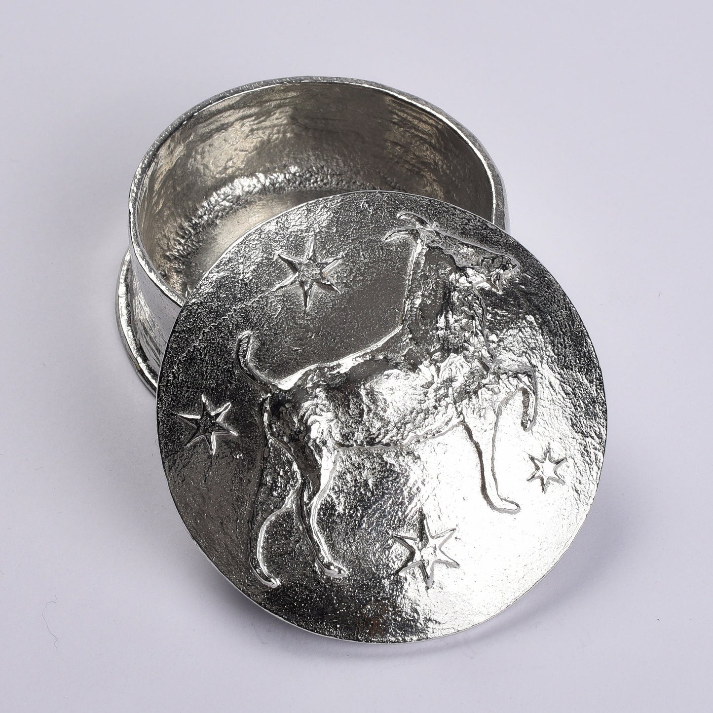 A beautifully detailed and textured Capricorn goat zodiac sign guards precious treasure on this personalised pewter trinket box. The underside of the lid can be engraved with your personalised message. Birthday gifts for Capricorns - made in Britain.