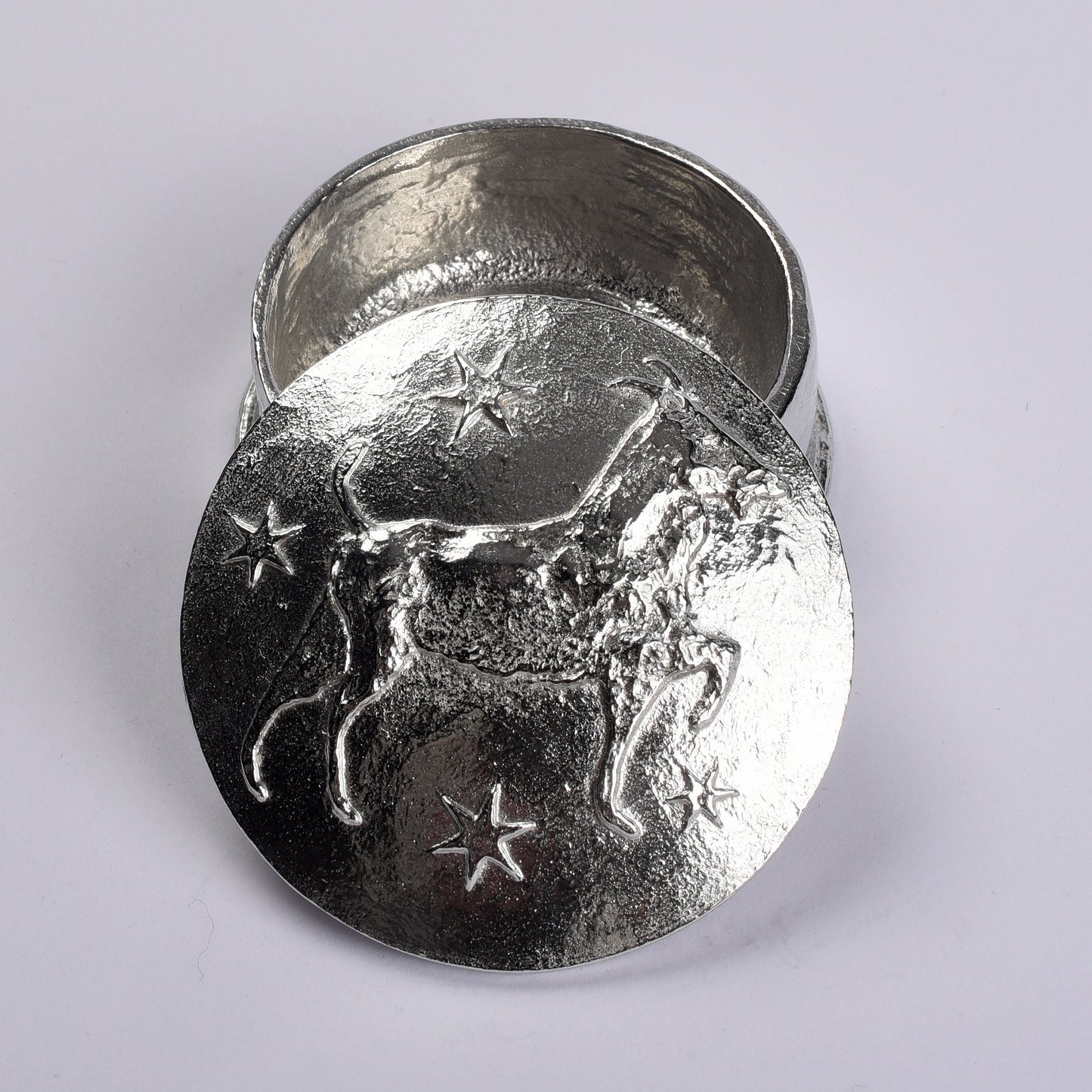 A beautifully detailed and textured Capricorn goat zodiac sign guards precious treasure on this personalised pewter trinket box. The underside of the lid can be engraved with your personalised message. Birthday gifts for Capricorns - made in Britain.