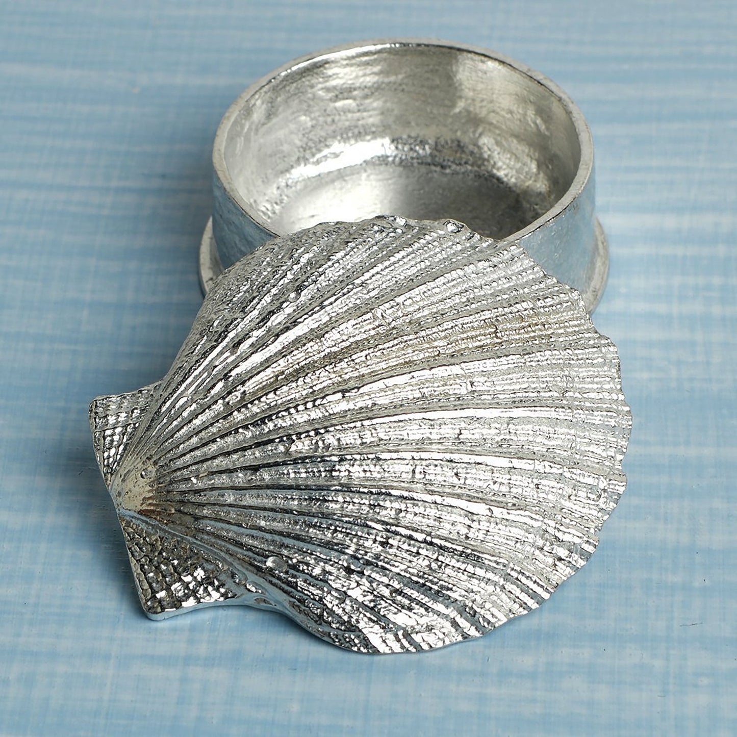 A round pewter trinket box with a scallop shell lid. Nautical gifts for lovers of the seaside and sea life.