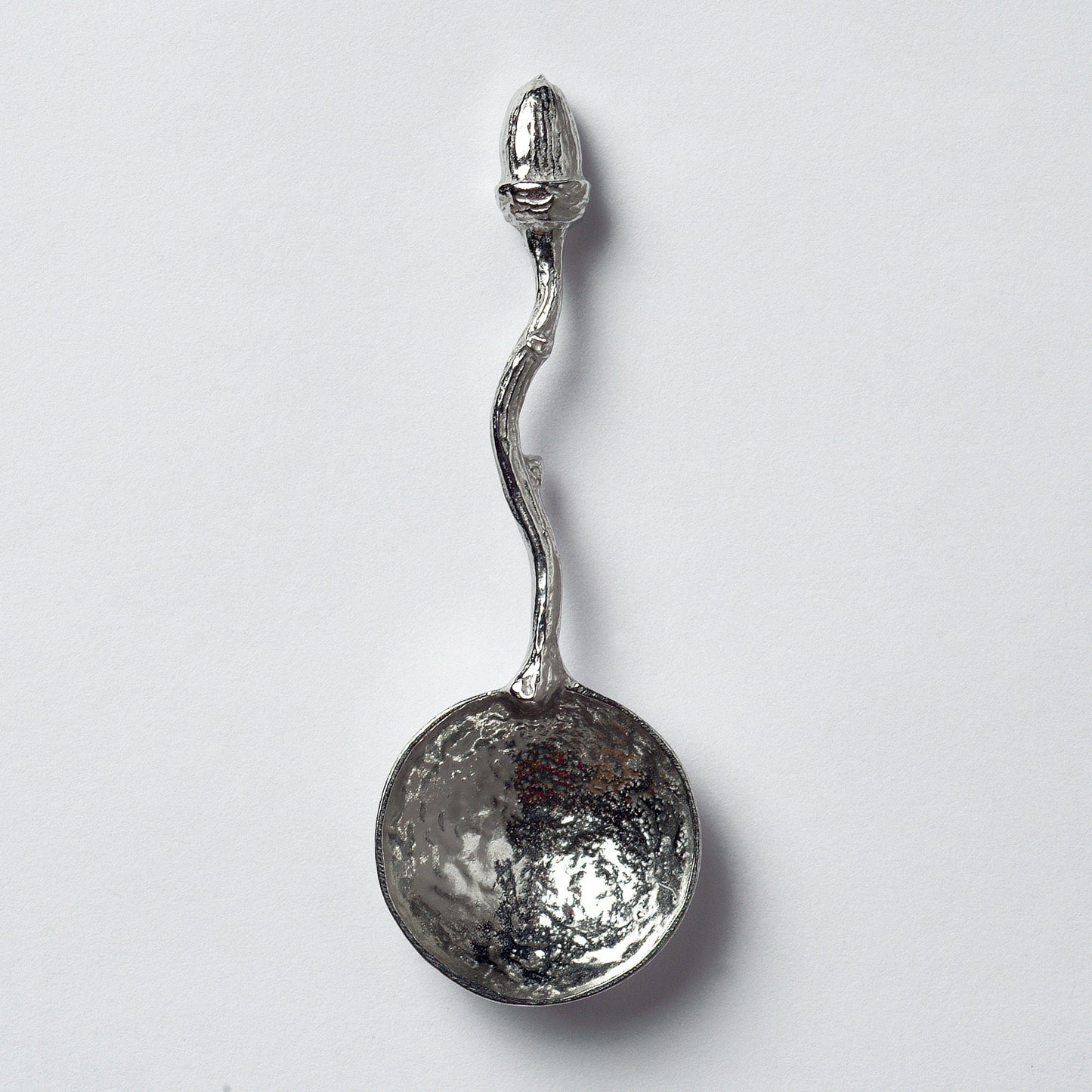 A small spoon pewter sugar spoon with an acorn on the end of a twig handle. Unusual, useful and tactile little acorn gifts handmade in the UK