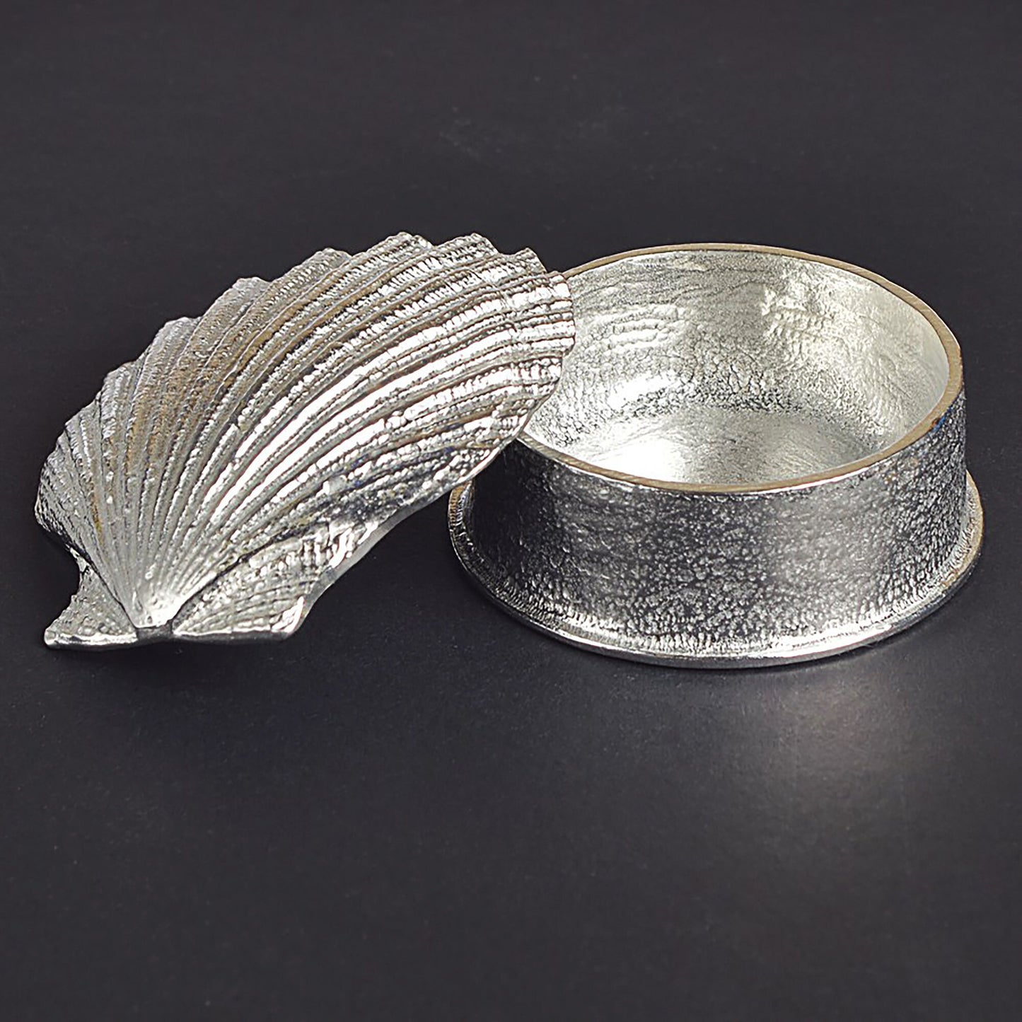 A round pewter trinket box with a scallop shell lid. Nautical gifts for lovers of the seaside and sea life.