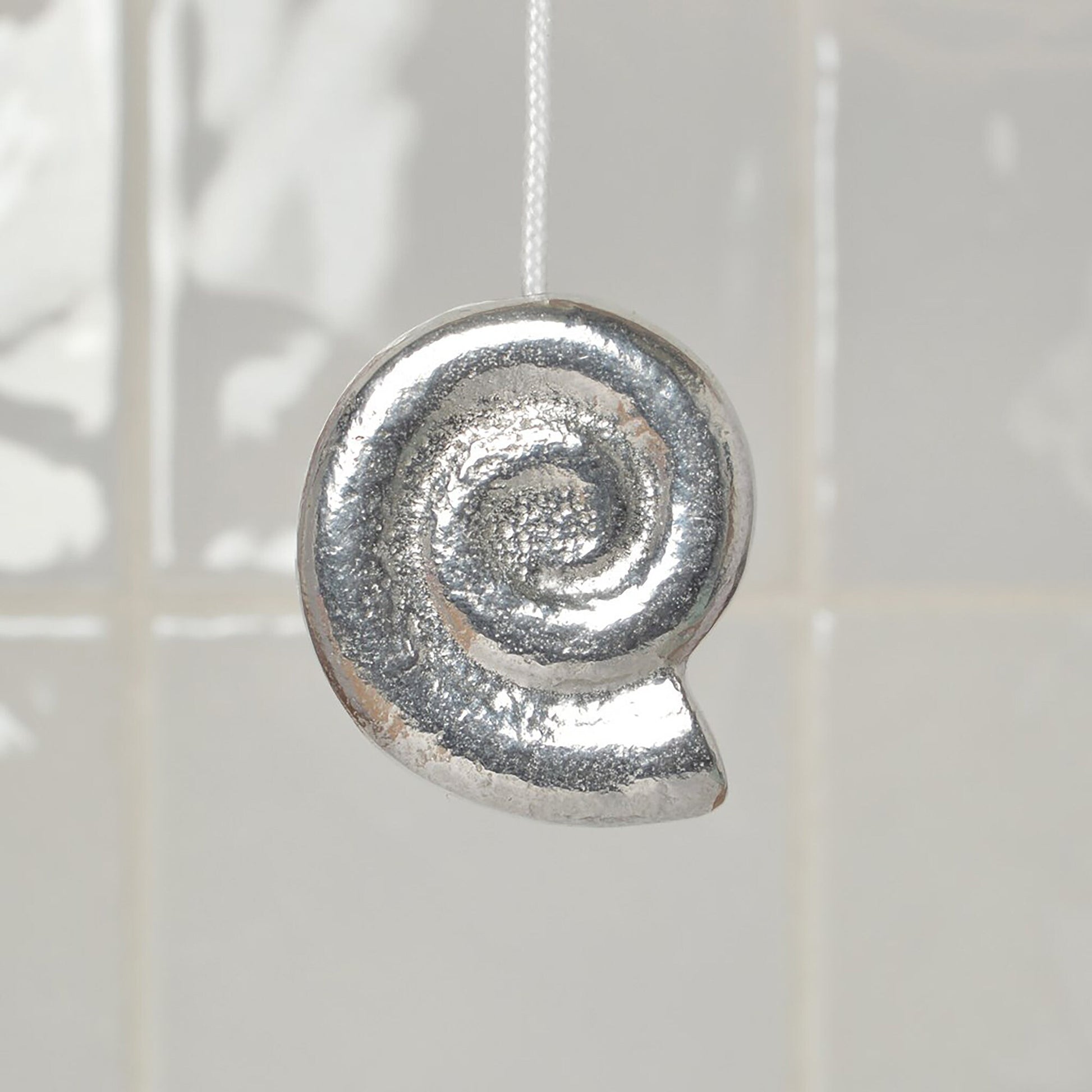 Whirley shell bathroom light pull or cord pull. A tactile and decorative pewter Whirley shell hangs at the bottom of the bathroom light switch cord. ideal little housewarming gifts.