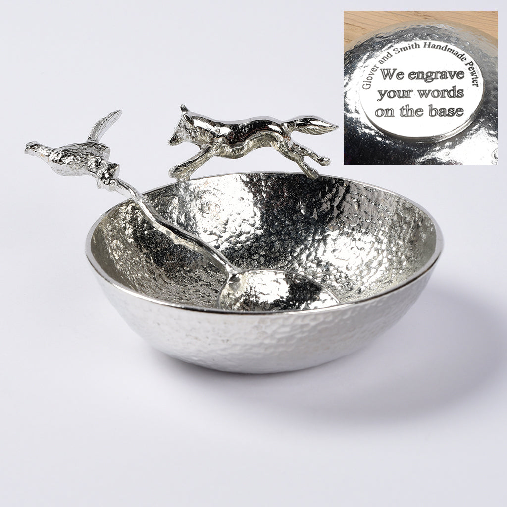 A 9cm diameter textured circular pewter bowl, with a striking fox running around the edge of the dish, comes with accompanying pheasant spoon. Great hunting and shooting gifts for lovers of the British countryside and country pursuits. We engrave the base with your message.