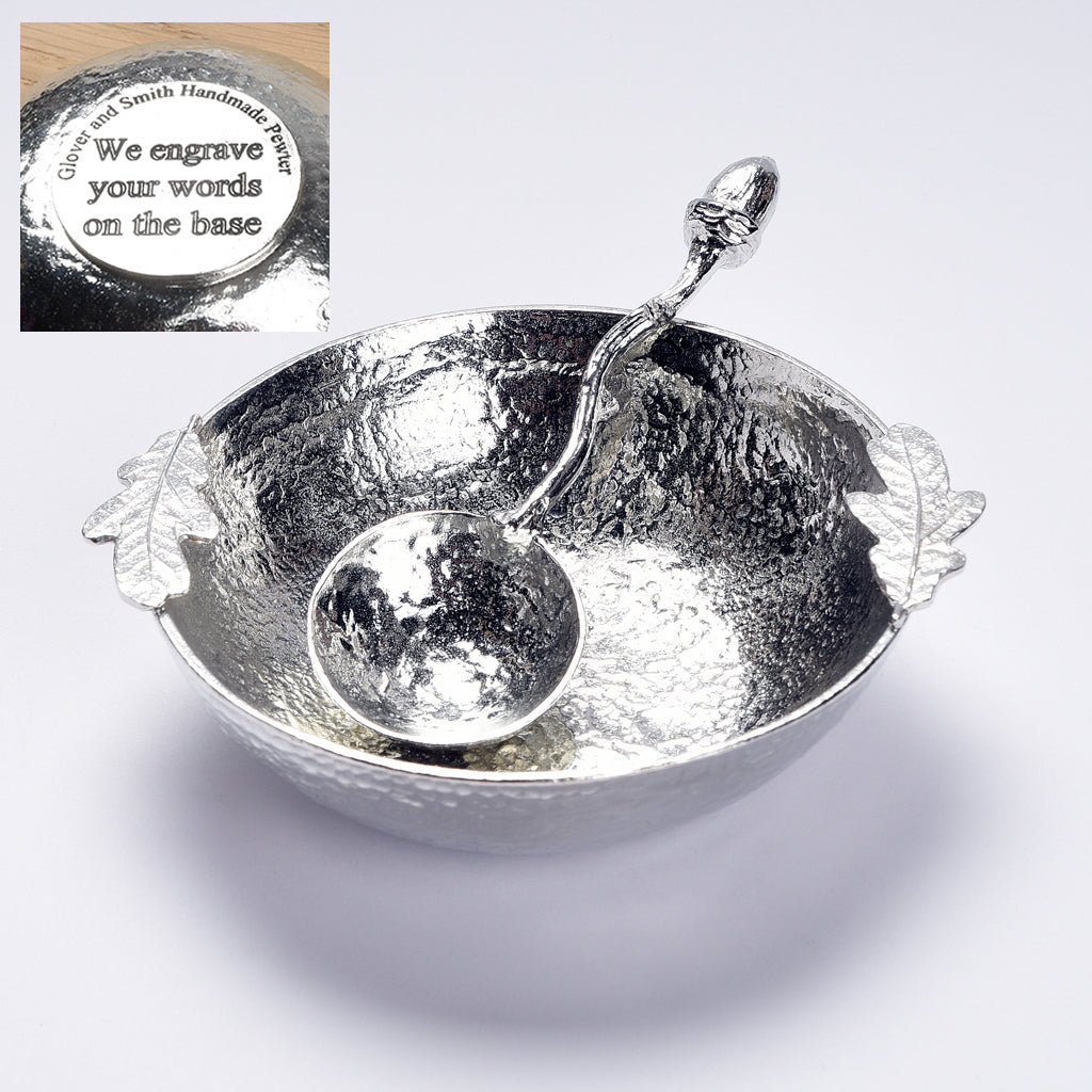 A 9cm diameter textured circular pewter bowl, with two oak leaves on the edge of the dish, comes with accompanying acorn spoon. Gifts for nature lovers, oak and acorn gifts. 'Great oaks from little acorns grow'. We engrave the base with your message.