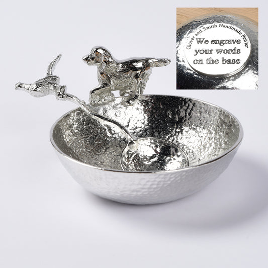 A 9cm diameter textured circular pewter bowl, with a springer spaniel bounding around the edge of the bowl, comes with accompanying pheasant spoon. Great spaniel gifts. Dog Lover Gifts, country gifts UK handmade. We engrave the base with your message.