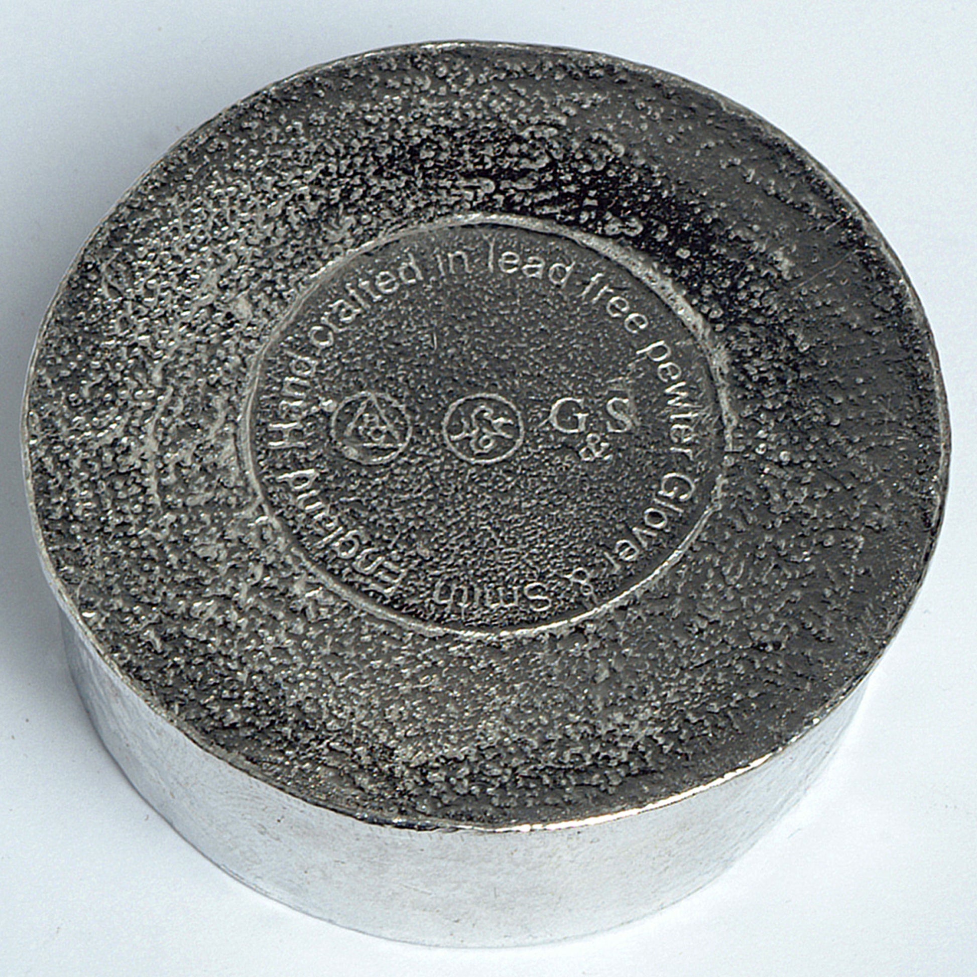 The underside of a Glover and Smith pewter box showing their makers marks