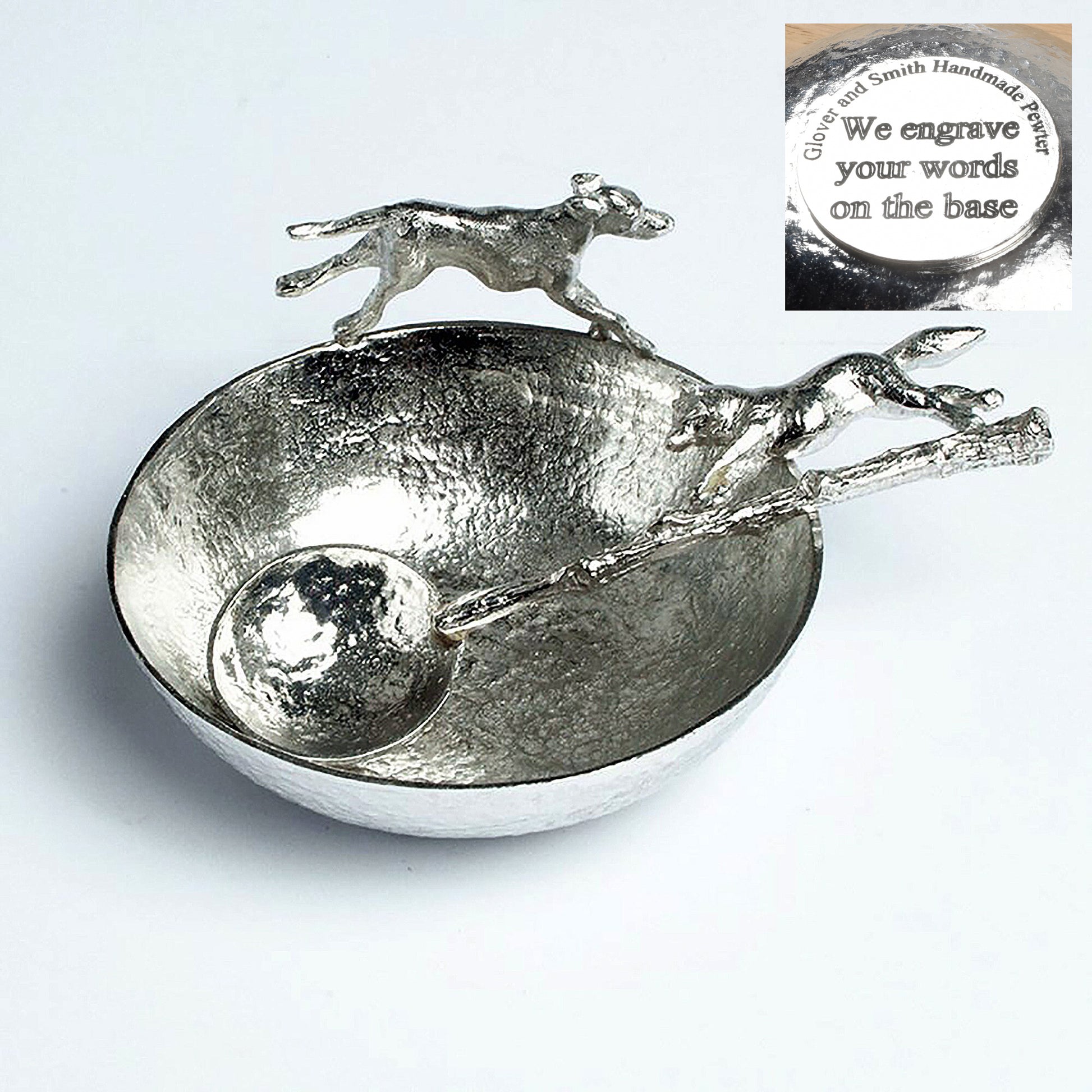 A  hound bounds around the rim of a textured, circular pewter bowl, chasing the accompanying spoon with a cunning fox on the end of its handle. Perfect gifts for lovers of the great British countryside. Country gifts, hunting gifts. We engrave the base with your words