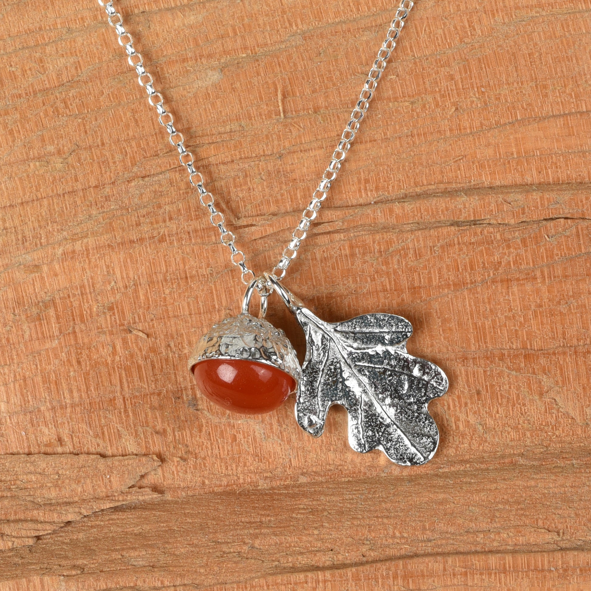 Carnelian acorn pewter necklace on a wooden background