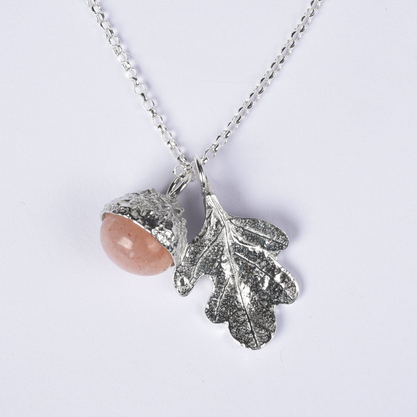moonstone in a pewter acorn cup with an oak leaf on a Sterling silver necklace. white background