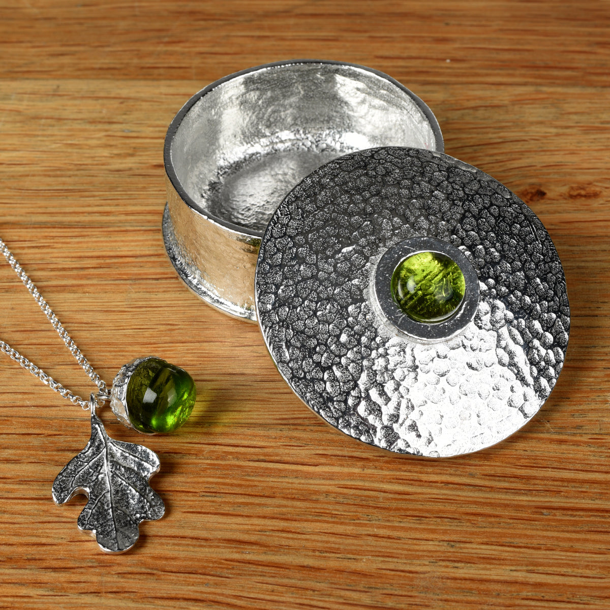Peridot personalised, engraved birthstone box with peridot acorn oak leaf necklace on a wooden surface. August birthstone gifts