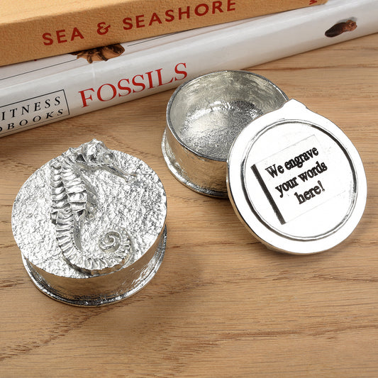 A round  pewter trinket box with a seahorse on the lid. We personalise it by engraving on the underside of the lid. Nautical gifts for lovers of the seaside and sea life. Seahorse gifts, gifts for seahorse lovers.