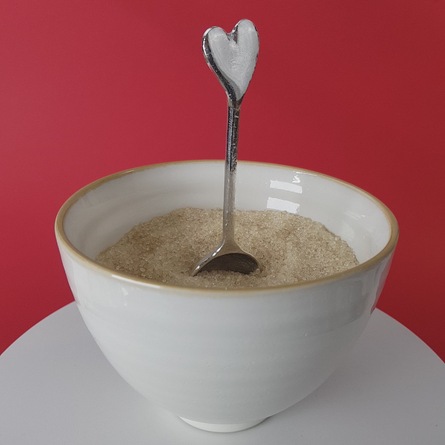Video of a handmade pewter spoon with a heart handle. The spoon is in a revolving sugar bowl.