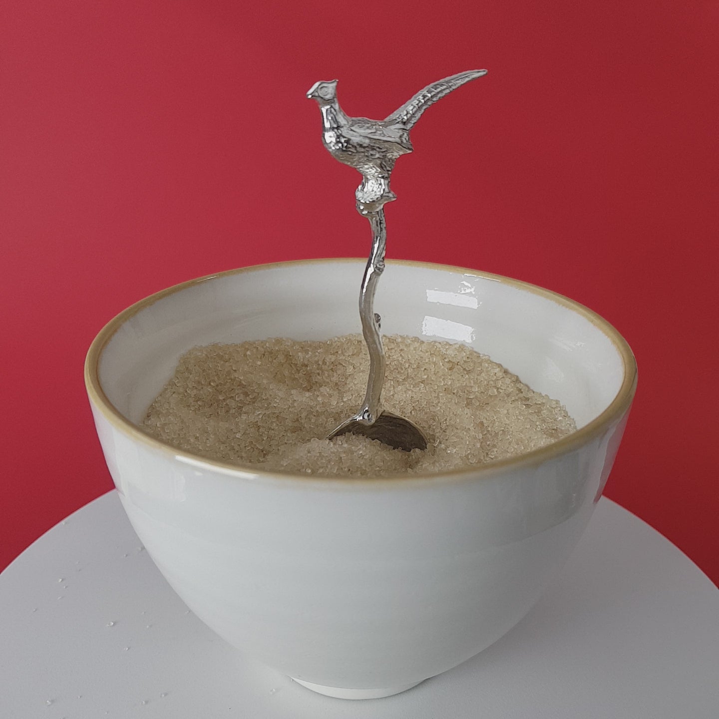 Video of a handmade pewter spoon with a pheasant on the handle. The spoon is in a revolving sugar bowl.