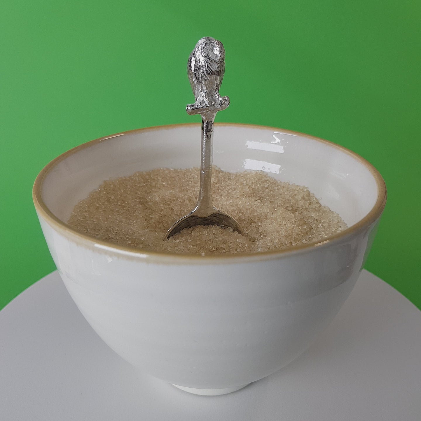Video of a handmade pewter spoon with an owl on the handle. The spoon is in a revolving sugar bowl.