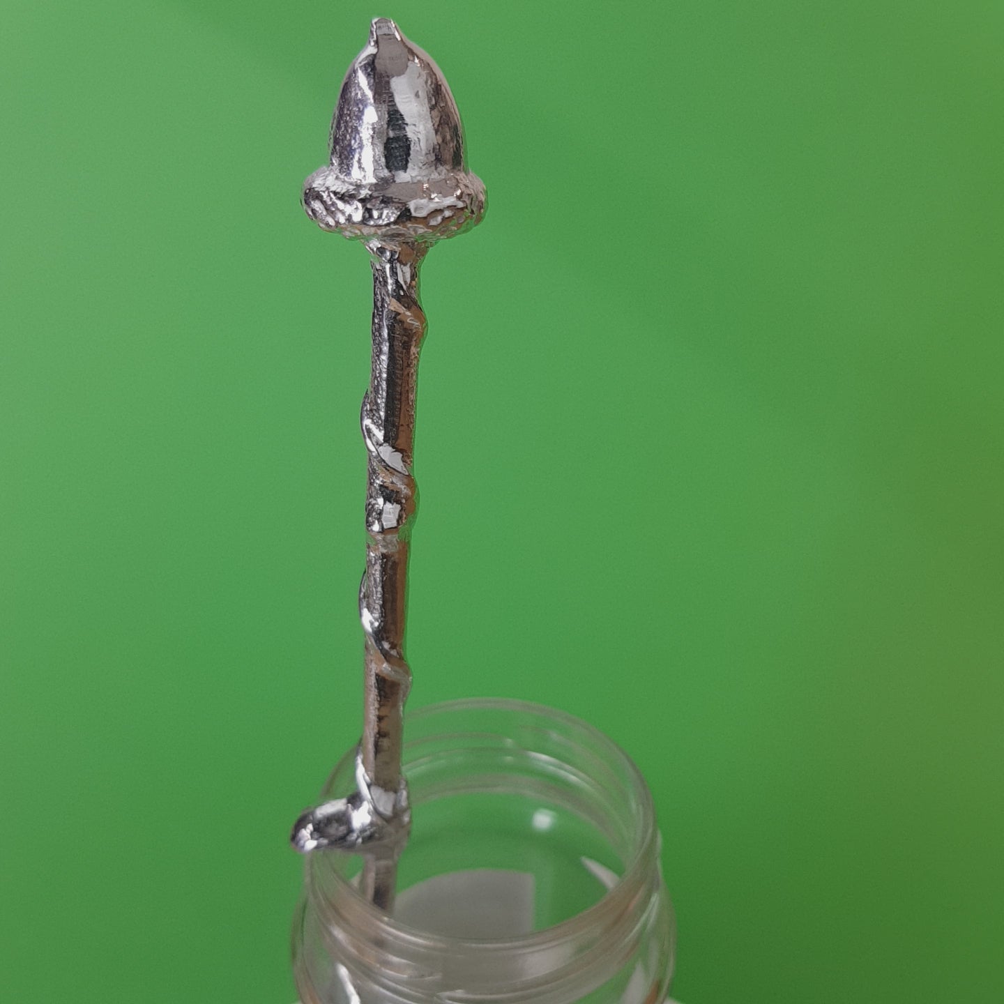 Long pewter jam spoon with a hook to hang on any jar. The top of the spoon has an acorn sculpture on it.