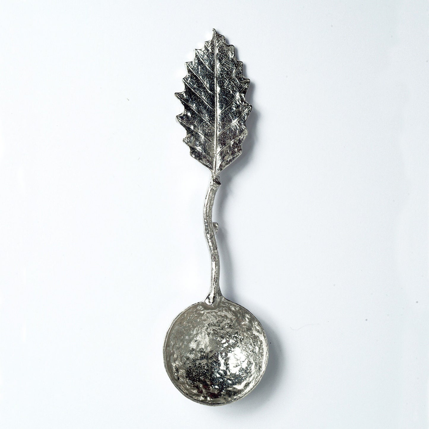 A small spoon pewter sugar spoon with a detailed chestnut leaf on the end of a twig handle. Unusual, useful and tactile gifts for nature lovers handmade in the UK