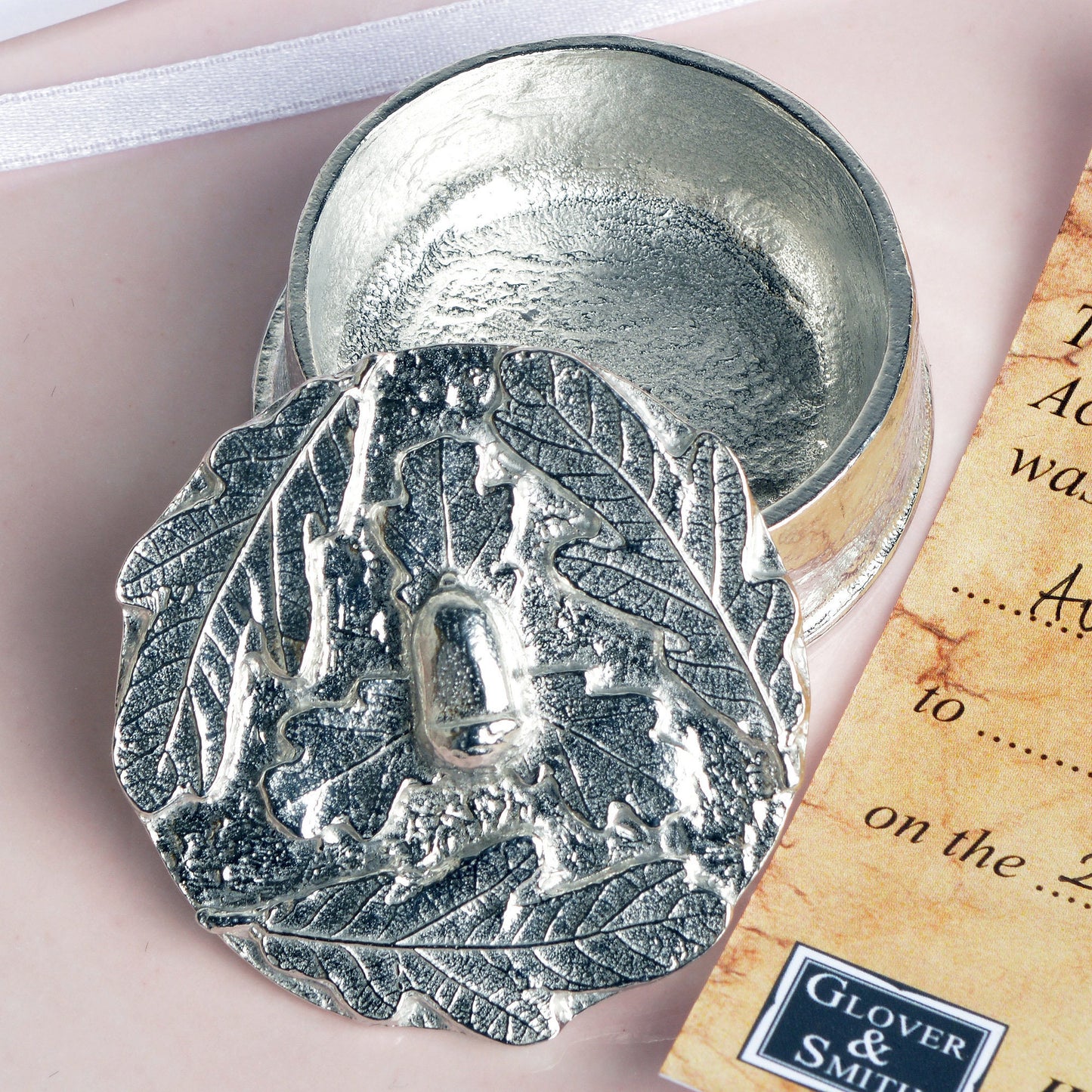 A personalised, engraved pewter little acorns box. The lid has an acorn surrounded by a garland of oak leaves. 'Great oaks from little acorns grow' is written under the lid. Christening gifts for boys and girls