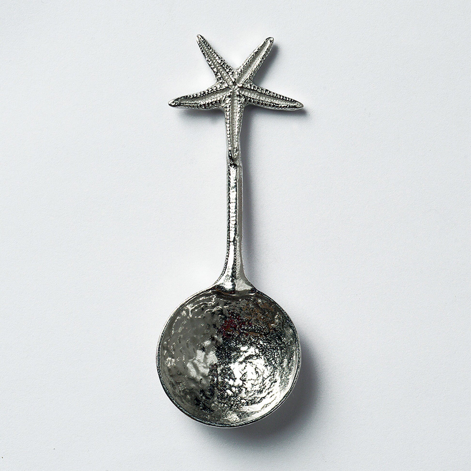 A small spoon pewter sugar spoon. A round bowled spoon on a straight handle leads to a perfectly sculpted starfish. Practical & useful nautical gifts for starfish lovers. UK handmade