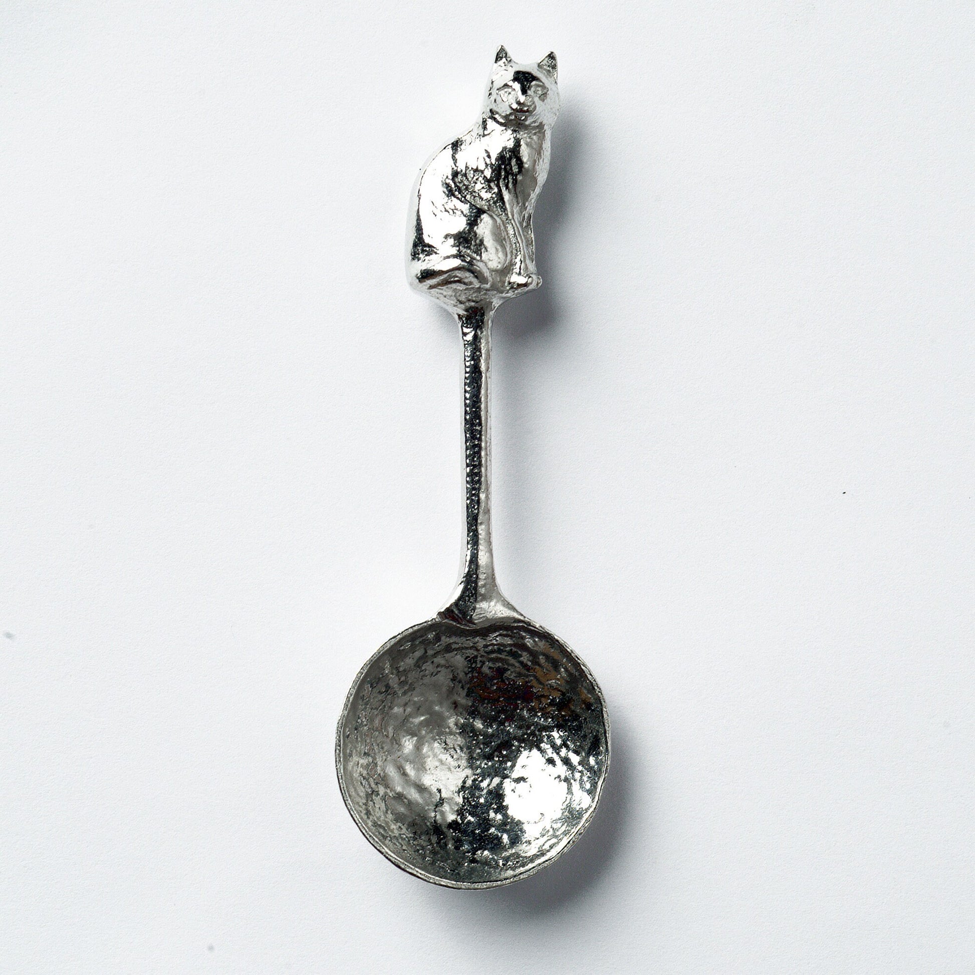 A small spoon pewter sugar spoon. A round bowled spoon on a straight handle leads to a perfectly sculpted cat. Practical & useful cat gifts for cat lovers. UK handmade