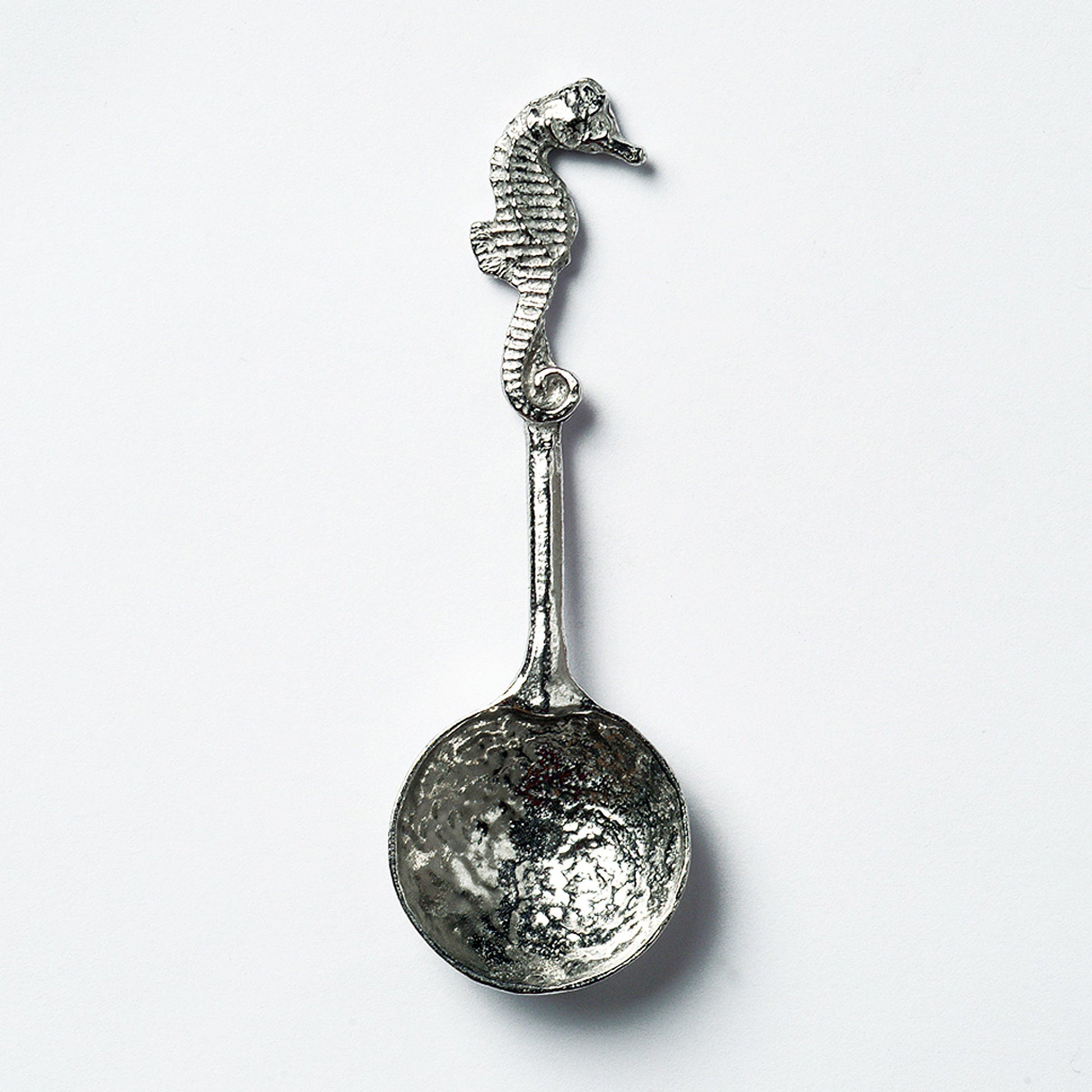 A small spoon pewter sugar spoon. A round bowled spoon on a straight handle leads to a perfectly sculpted seahorse. Practical & useful nautical gifts for seahorse lovers. UK handmade