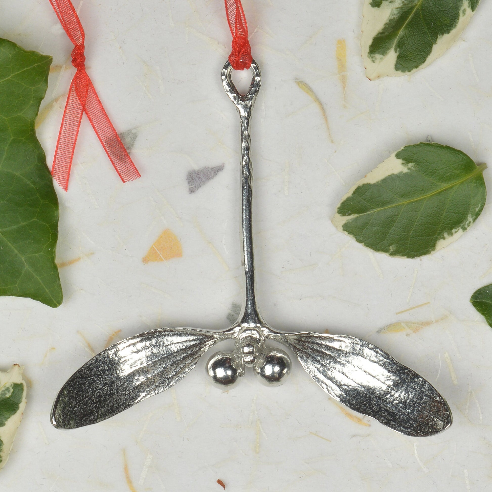 Our beautifully textured & detailed pewter Mistletoe hangs from a red ribbon providing a gorgeous hanging Christmas tree decoration gifts. Pewter Christmas tree decorations, unusual Christmas decorations made in Britain