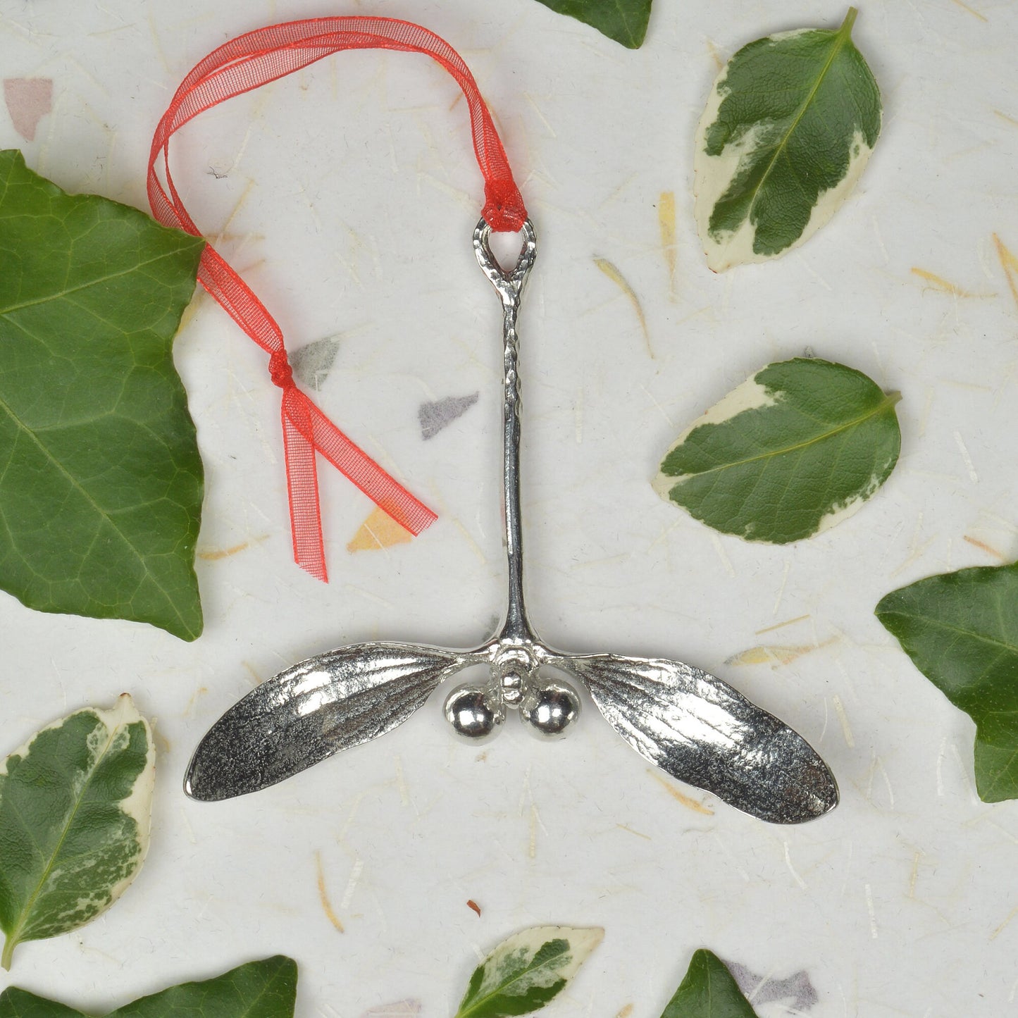 Our beautifully textured & detailed pewter Mistletoe hangs from a red ribbon providing a gorgeous hanging Christmas tree decoration gifts. Pewter Christmas tree decorations, unusual Christmas decorations made in Britain