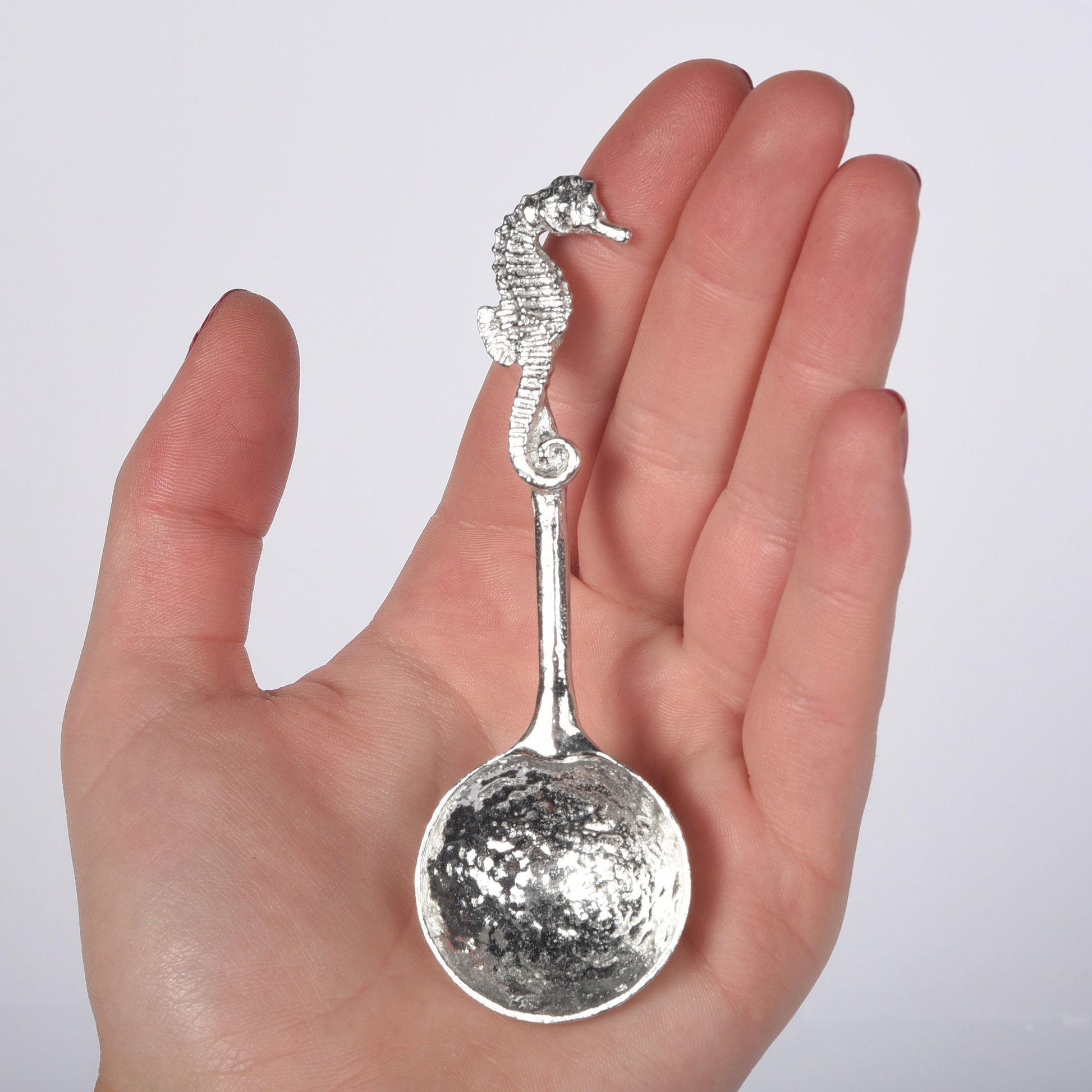 A small spoon pewter sugar spoon. A round bowled spoon on a straight handle leads to a perfectly sculpted seahorse. Practical & useful nautical gifts for seahorse lovers. UK handmade