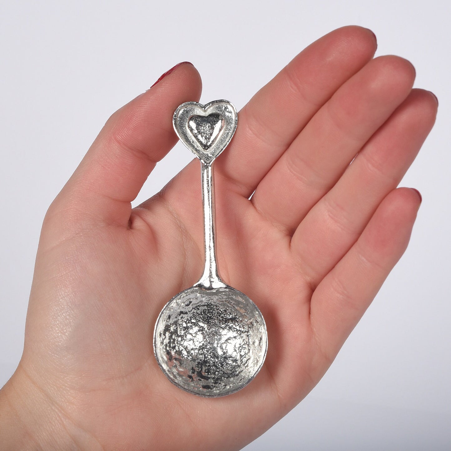 A small spoon pewter sugar spoon  with 2 love hearts on the end. Our love spoon makes an ideal little love token or 10th tin wedding anniversary gift or small wedding gift.