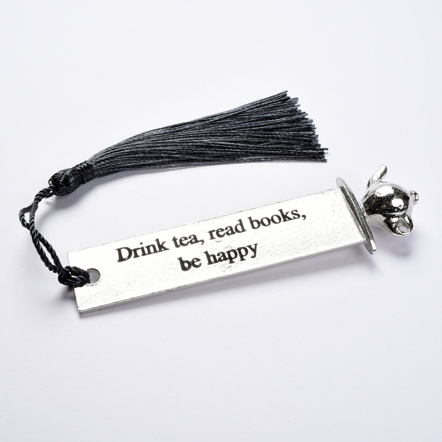 A personalised engraved pewter metal  bookmark with a teapot on the top. On the front the quotation 'Drink tea, read books be happy'. We engrave the back with your message. Gifts for tea lovers, book lovers gifts.