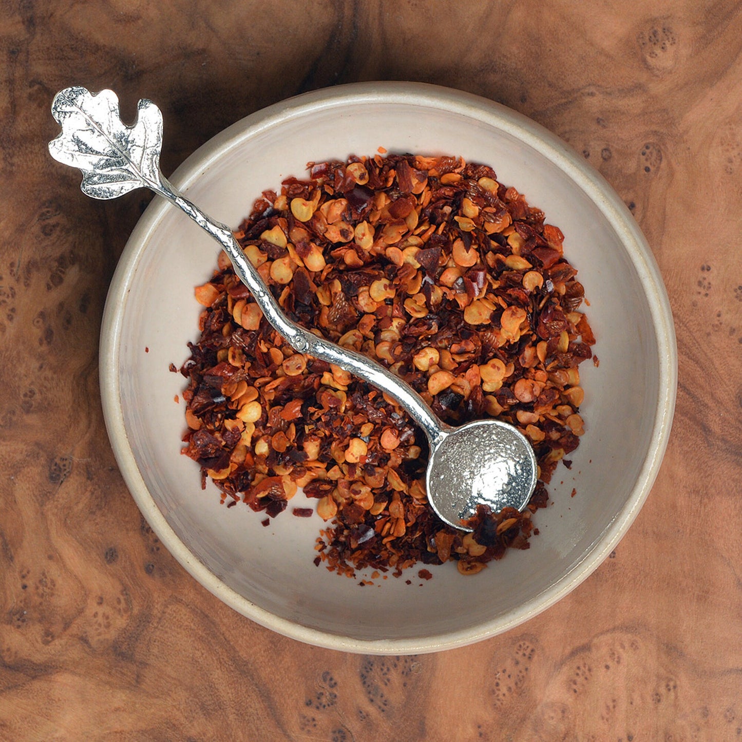 a tiny spice, salt or condiment spoon. Our pewter spoon has a small 10mm bowl leading up a fine twig textured handle to a small oak leaf. Practical & useful gifts for nature lovers.