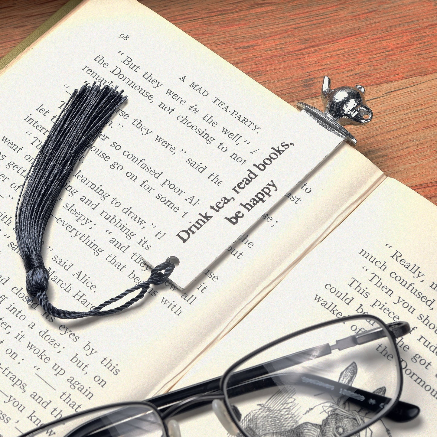 A personalised engraved pewter metal  bookmark with a teapot on the top. On the front the quotation 'Drink tea, read books be happy'. We engrave the back with your message. Gifts for tea lovers, book lovers gifts.