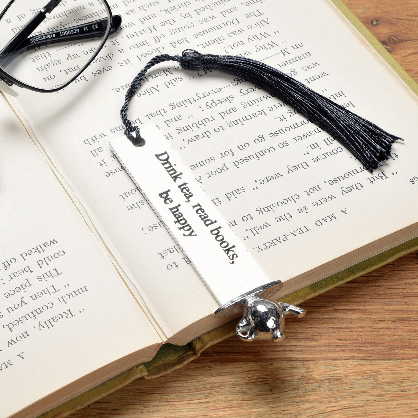 A personalised engraved pewter metal  bookmark with a teapot on the top. On the front the quotation 'Drink tea, read books be happy'. We engrave the back with your message. Gifts for tea lovers, book lovers gifts.