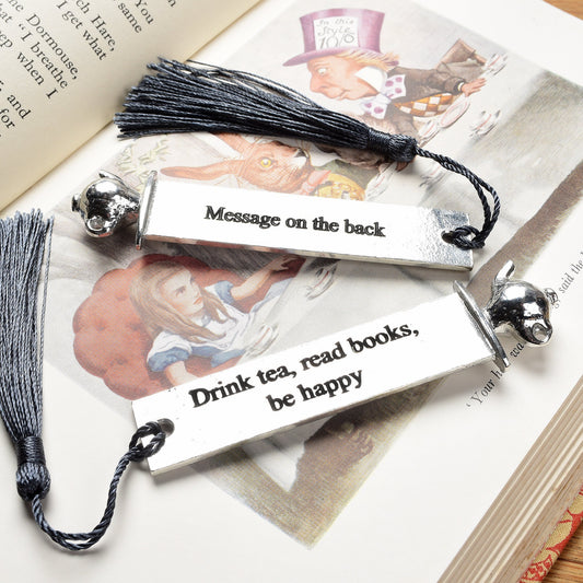 A personalised engraved pewter metal  bookmark with a teapot on the top. On the front the quotation 'Drink tea, read books be happy'. We engrave the back with your message. Gifts for tea lovers, book lovers gifts.