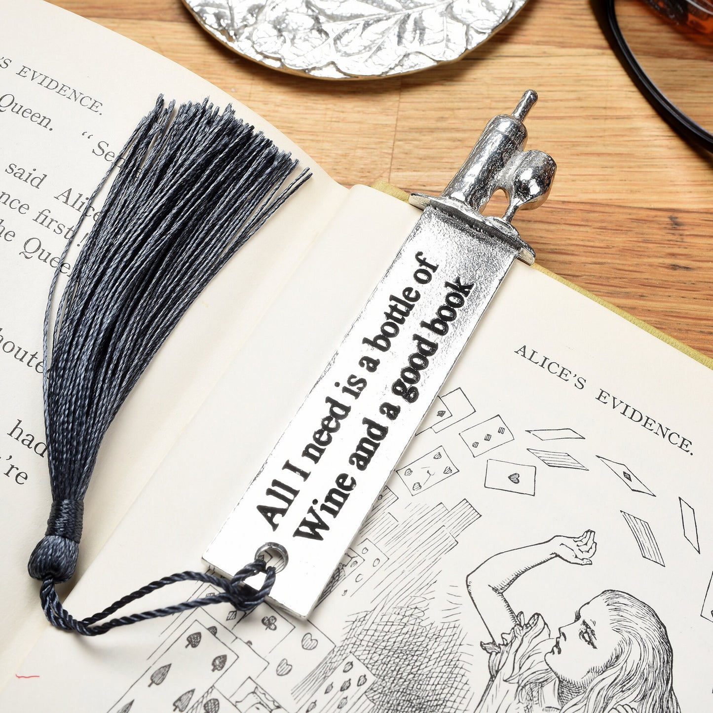 A personalised engraved pewter metal  bookmark with a wine bottle and glass on the top. On the front the quotation 'All I need is a bottle of wine and a good book'. We engrave the back with your message. Gifts for wine lovers, book lovers gifts.