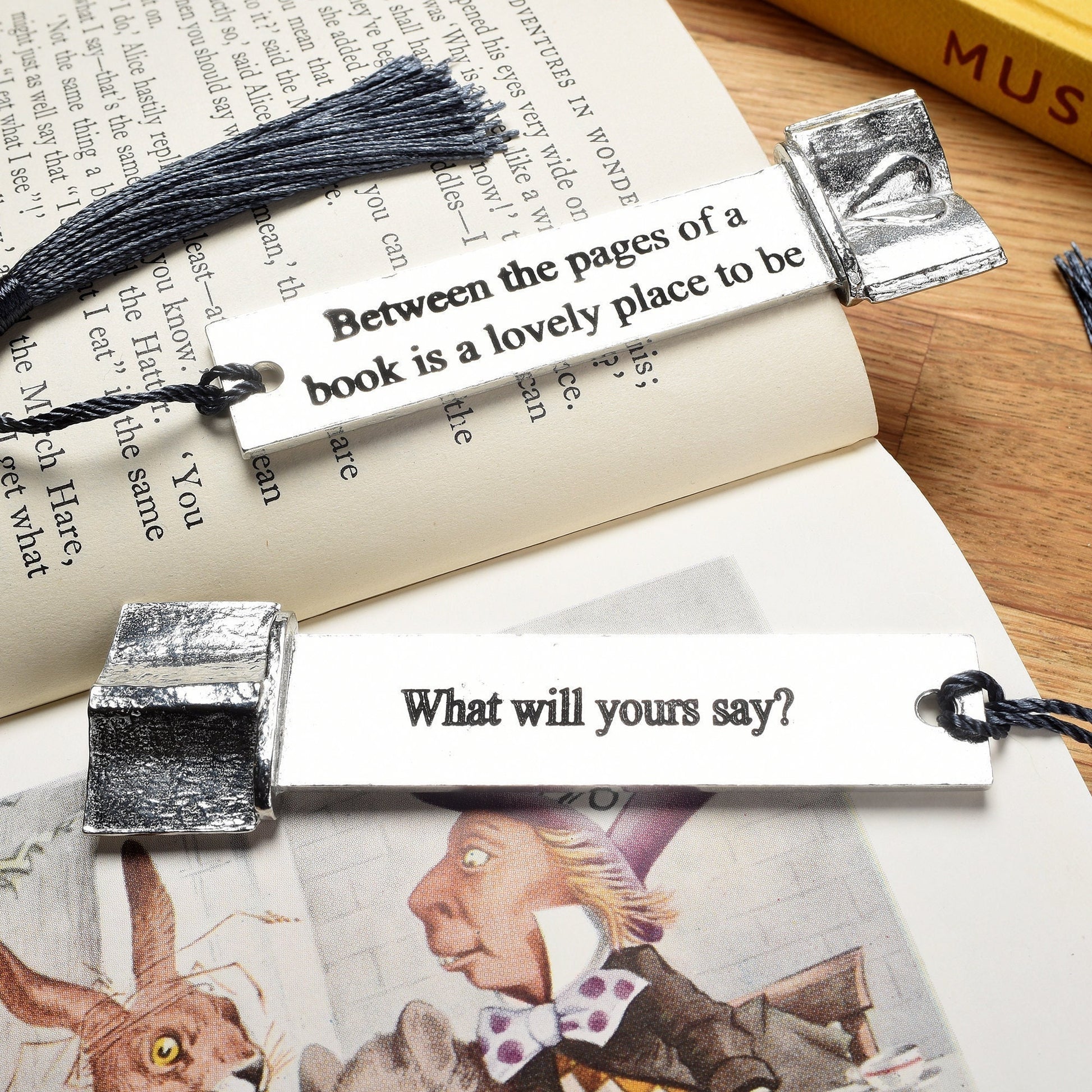 A personalised engraved pewter metal  bookmark with a heart on an open book on the top. On the front the quotation 'Between the pages of a book is a lovely place to be'. Gifts for book lovers, book gifts, bookmarks for books