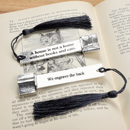 A personalised engraved pewter metal  bookmark with a cat silhouette wandering across an open book on the top. On the front the quotation 'A house is not a home without books and cats'. We engrave the back with your message. Gifts for cat lovers, book lovers gifts, cat gifts.