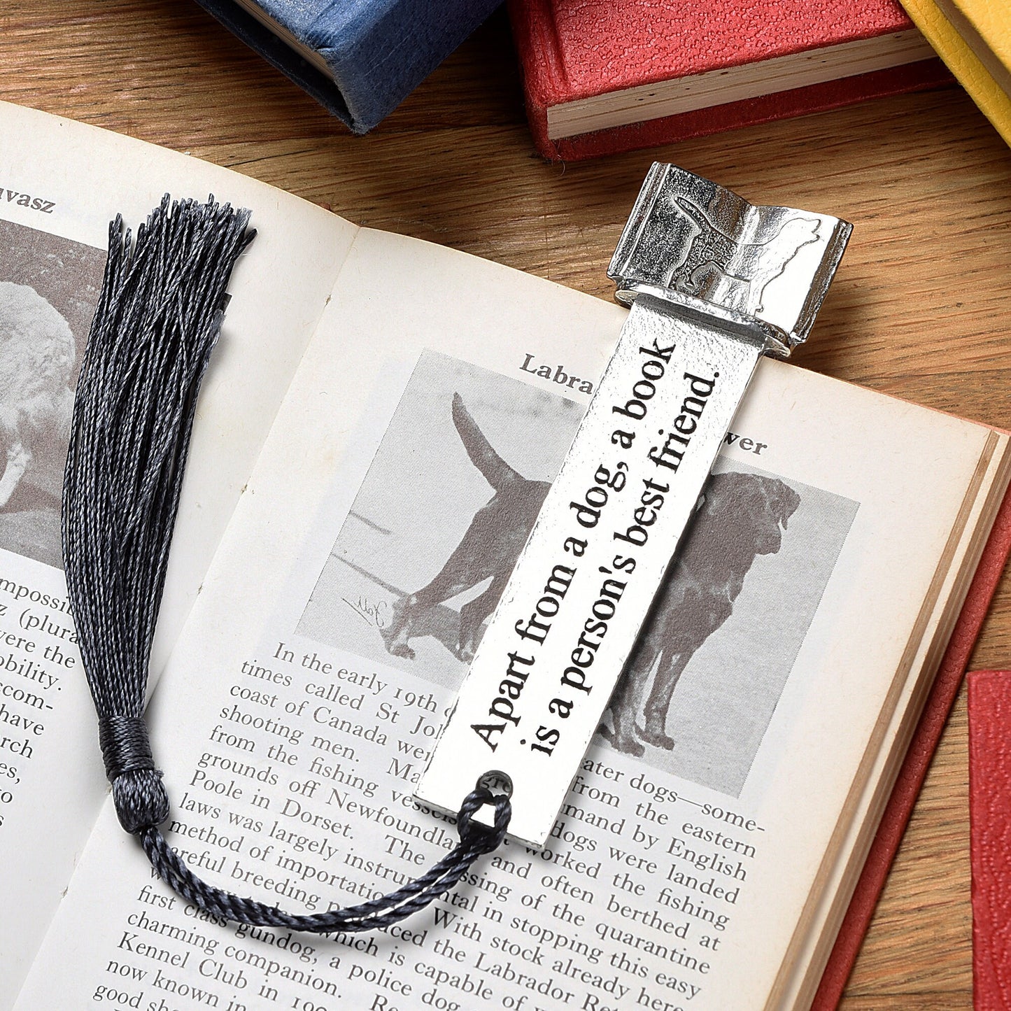 A personalised engraved pewter metal  bookmark with a dog silhouette on an open book on the top. On the front the quotation 'Apart from a dog, a book is a person's best friend'. We engrave the back with your message. Gifts For Dog Lovers, book lovers gifts, dog gifts.