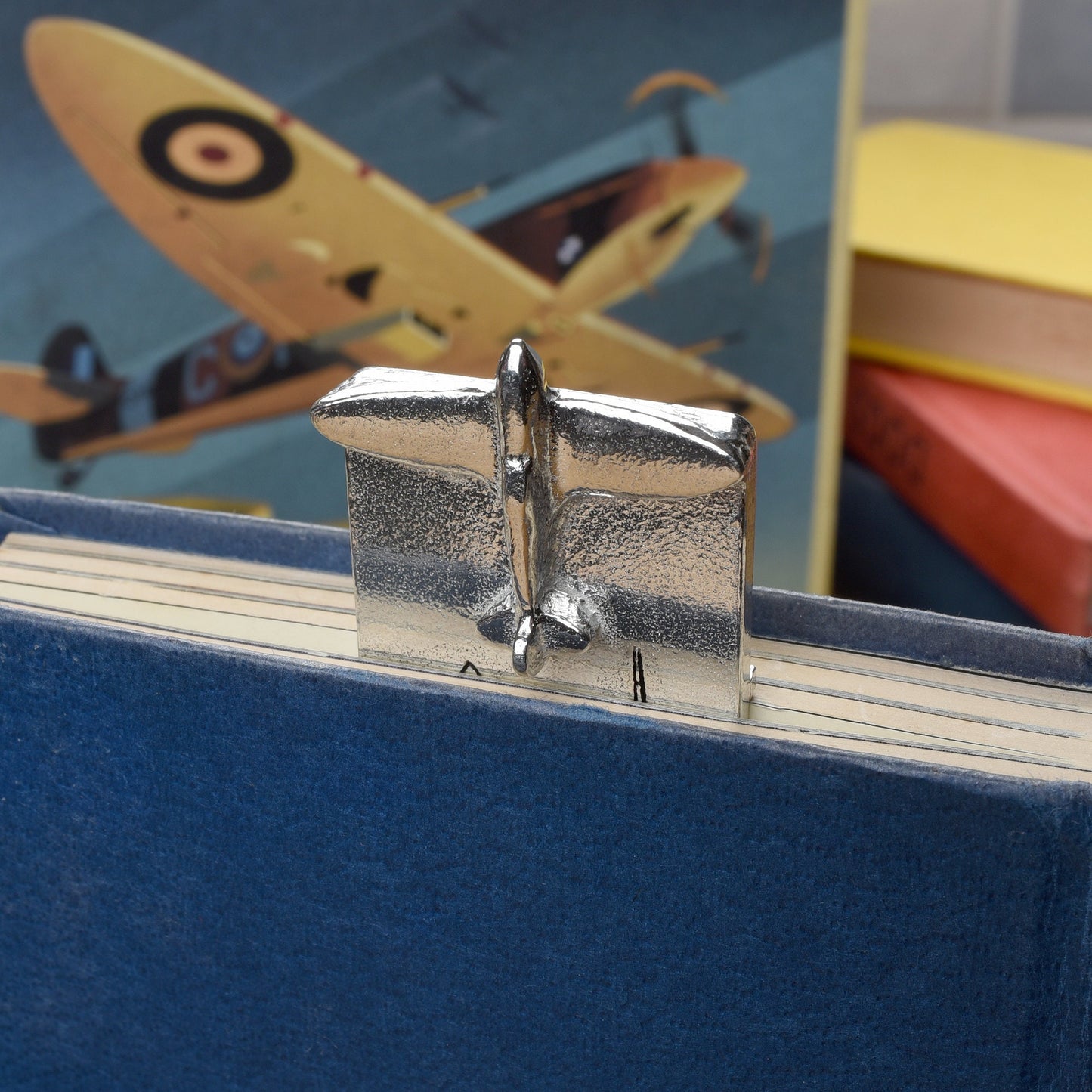 A personalised engraved pewter metal  bookmark with a Spitfire aeroplane sculpture on the top. On the front are blueprint drawings of a mark IX Spitfire. We engrave the back with your message. Personalised Spitfire gifts.